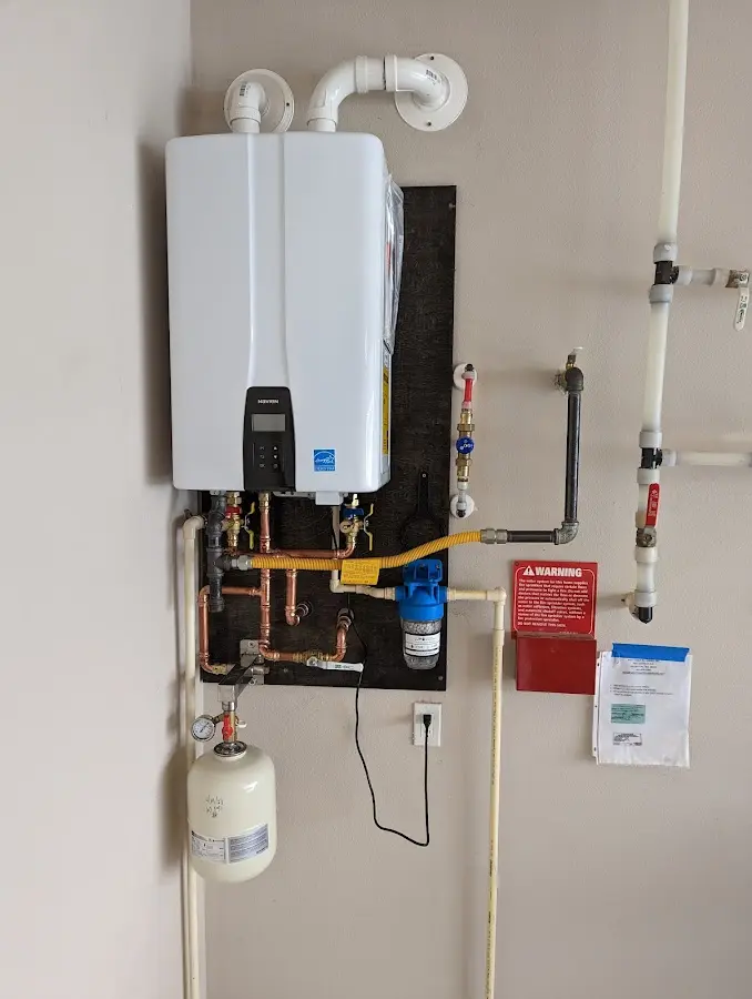 Professional plumber installing copper piping in a Harvard home